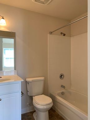 Laurel apartment for rent - A white toilet sits next to a white sink in a bathroom.