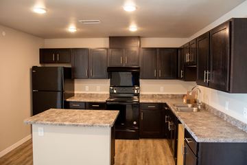 Moorhead apartment for rent - a kitchen with black appliances and granite counter tops