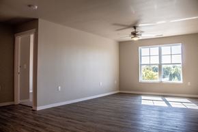 Moorhead apartment for rent - an empty living room with a ceiling fan and a window
