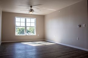 Moorhead apartment for rent - an empty living room with a ceiling fan and a window