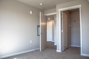 Moorhead apartment for rent - a bedroom with a closet and a hallway with a door open