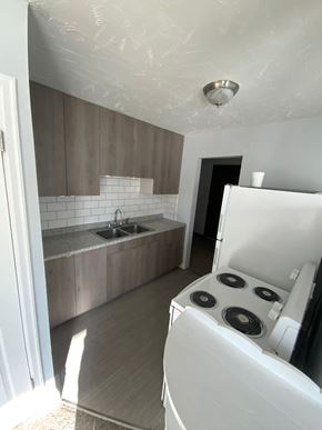 Fremont apartment for rent - A white oven in a kitchen with wooden cabinets and a white fridge.