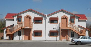 Tucson apartment for rent - A white building with red roof and a car in front.