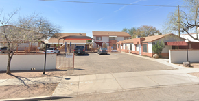 Tucson apartment for rent - A street view of a residential area with houses and a clear sky.