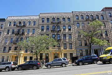New York apartment for rent - A yellow building with a black car in front of it.