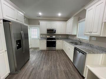 Wilson apartment for rent - A kitchen with white cabinets and a grey refrigerator.