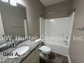 Wilson apartment for rent - A bathroom with a sink, toilet, and bathtub.