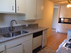 Los Angeles apartment for rent - a kitchen with white cabinets and granite counter tops and a sink
