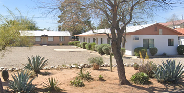 Tucson apartment for rent - a house with a gravel driveway and a tree in front of it