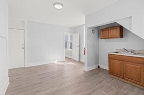 Philadelphia apartment for rent - A white room with a wooden cabinet and a window.