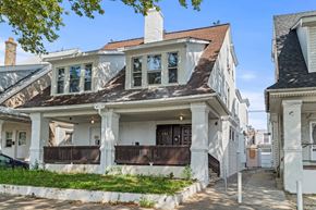 Philadelphia apartment for rent - A white house with a brown roof and a balcony.