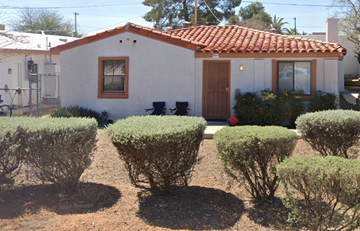 Tucson apartment for rent - A small white house with a red tile roof and a brown door.