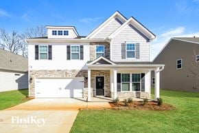 Greenville house for rent - A two-story house with a garage on the first floor and a balcony on the second floor.
