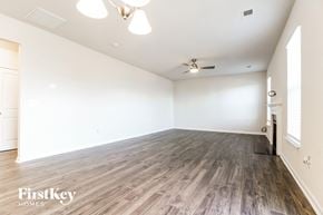 Greenville house for rent - A spacious room with wooden flooring and a ceiling fan.