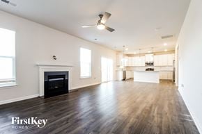 Greenville house for rent - A spacious living room with a fireplace and wooden floors.
