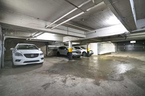 Montréal apartment for rent - A white car is parked in a garage with other cars.