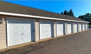 Sauk Rapids apartment for rent - a row of white garage doors on the side of a building