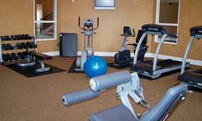 Sartell apartment for rent - a gym with cardio equipment and weights on the floor