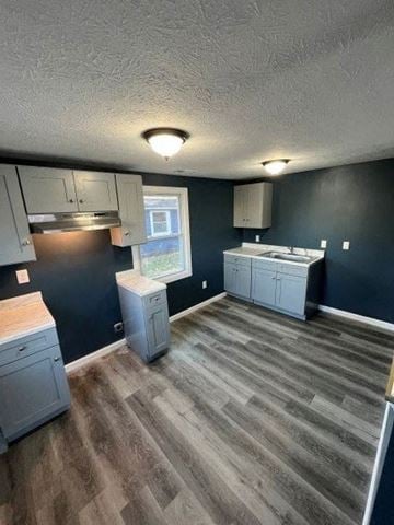 Medina house for rent - A kitchen with a wooden floor and grey cabinets.