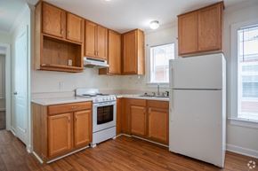 Ocean Springs apartment for rent - an empty kitchen with wooden cabinets and white appliances