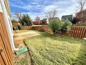 Simpsonville house for rent - a backyard with a wooden fence and a yard with grass