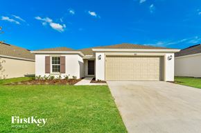Winter Haven house for rent - a beige house with a garage door and a lawn