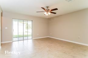 Winter Haven house for rent - A spacious room with a ceiling fan and sliding glass doors leading to a patio.