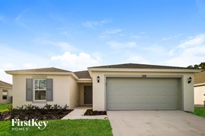 Winter Haven house for rent - a beige house with a garage door and grass