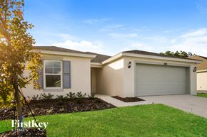 Winter Haven house for rent - the exterior of a house with a garage door and lawn