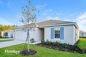 Winter Haven house for rent - a white house with blue shutters and a tree in the front yard