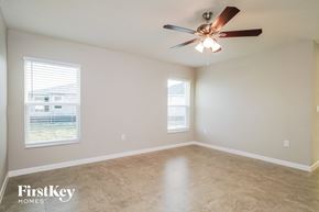 Winter Haven house for rent - an empty living room with a ceiling fan and two windows