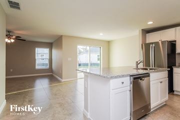 Winter Haven house for rent - a kitchen with white cabinets and a counter top