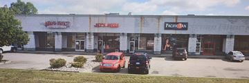 Grand Blanc apartment for rent - A red car is parked in front of a building with a sign that says "Jet's Pizza".