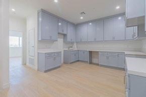 Inglewood apartment for rent - an empty kitchen with blue cabinets and a wooden floor