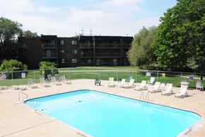 Lombard apartment for rent - A large swimming pool surrounded by chairs and apartment buildings.