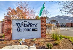 Naperville apartment for rent - a sign for waterford greens in front of a building