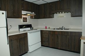 West Chicago apartment for rent - A kitchen with dark wood cabinets and white appliances.