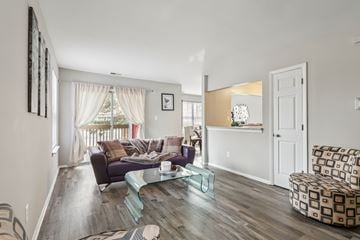 Monmouth Junction apartment for rent - A living room with a purple couch and a glass coffee table.