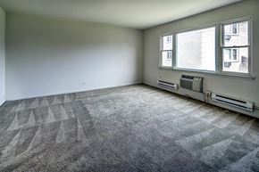 Broadview apartment for rent - A room with a carpeted floor and two windows.