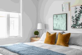 Ottawa apartment for rent - a bedroom with a bed with pillows and pictures on the wall