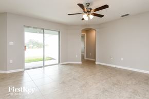 Davenport house for rent - an empty living room with a ceiling fan and sliding glass doors