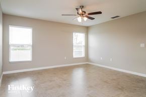 Davenport house for rent - A spacious room with a ceiling fan and two windows.