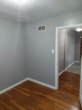 Morrow house for rent - a living room with a wooden floor and a hallway with an open door