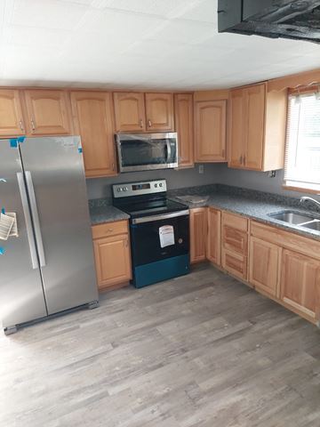 Morrow house for rent - a kitchen with wooden cabinets and stainless steel appliances
