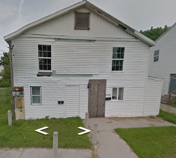 Pocomoke City house for rent - a white house with a boarded up window and a sidewalk