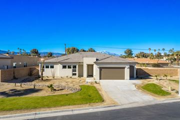 Indio house for rent - a house with a driveway and a garage door