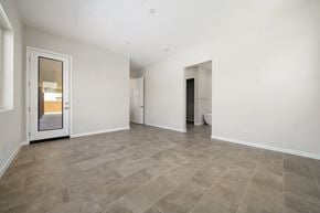 Indio house for rent - the living room of a new home with white walls and a door to the bathroom