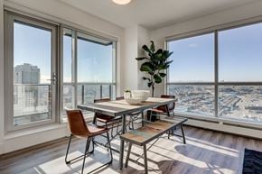 Calgary apartment for rent - a dining room with a view of the city and a table and chairs