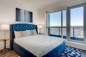 Calgary apartment for rent - a bedroom with a bed and a large window