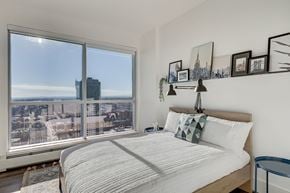 Calgary apartment for rent - a bedroom with a bed and a large window